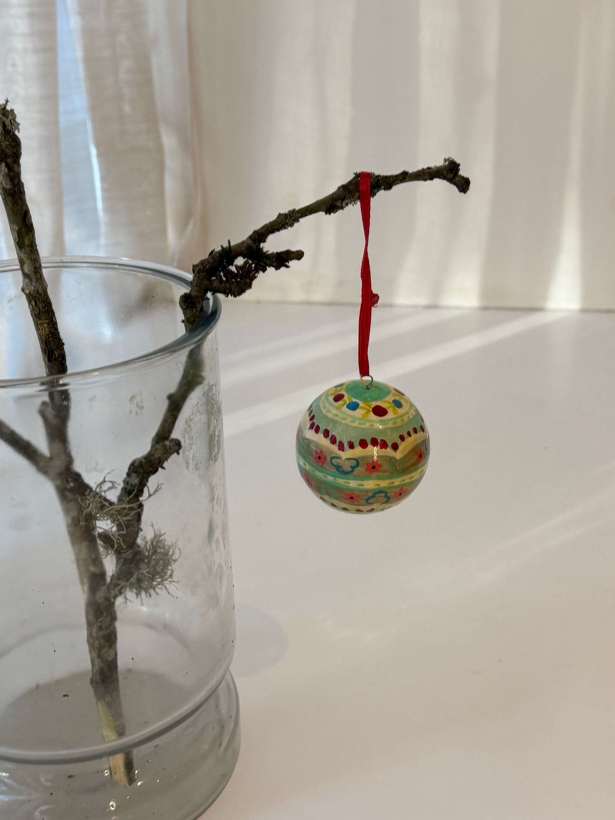 Håndmalede julekugler med rødt silkebånd