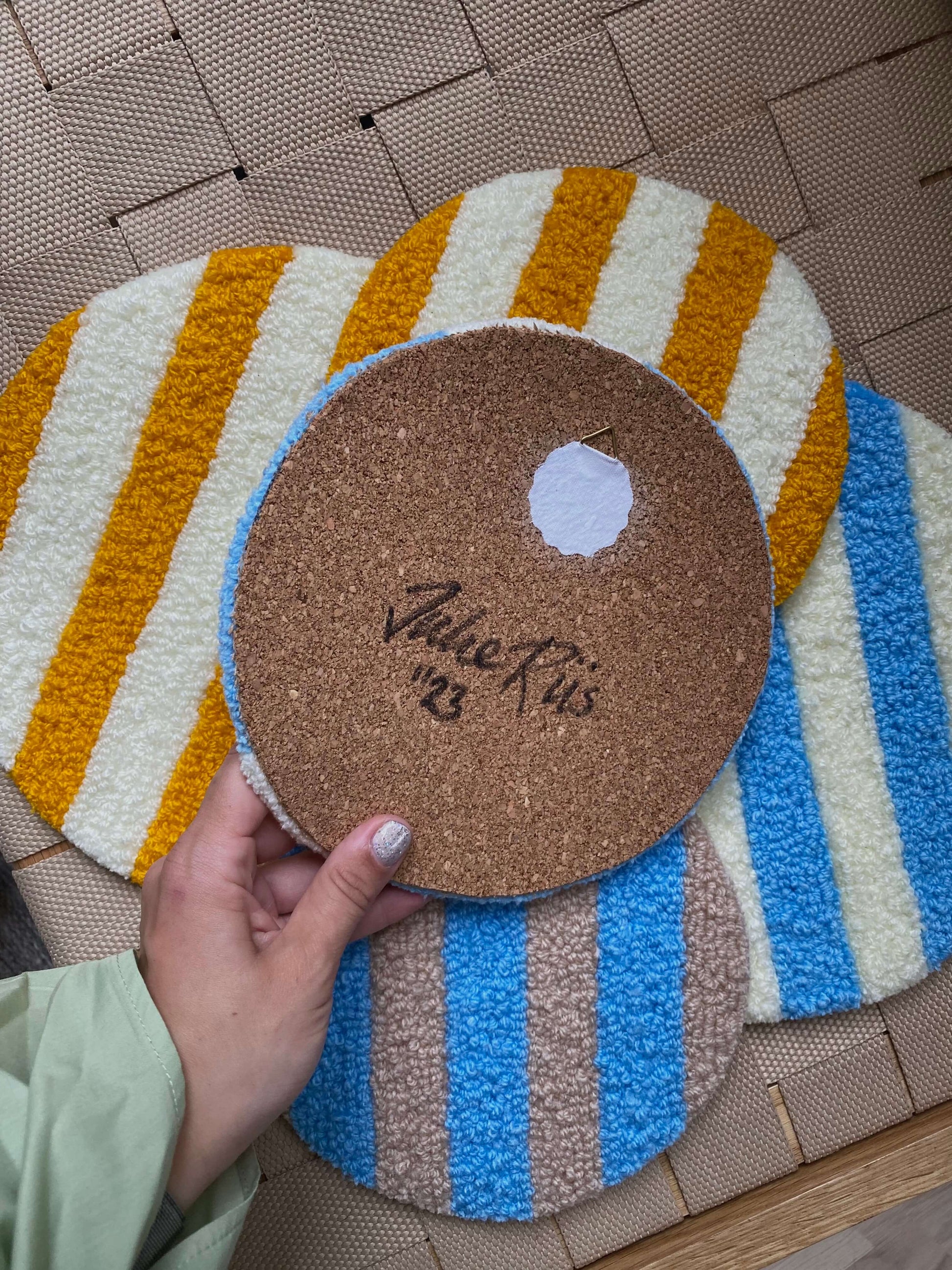 Håndlavet cirkeltæppe med blå og beige striber.