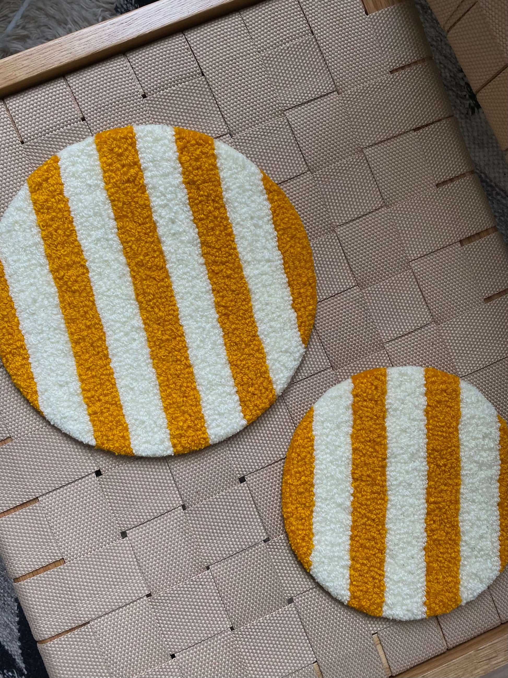 Cirkel vægtæpper i orange striber, lagt frem på kurv.