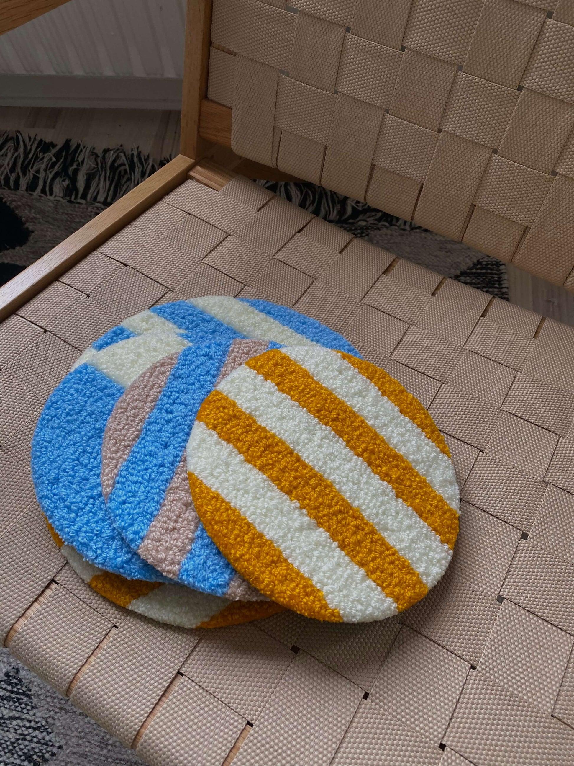 Cirkel vægtæpper i blå og orange striber, lagt frem på kurv.