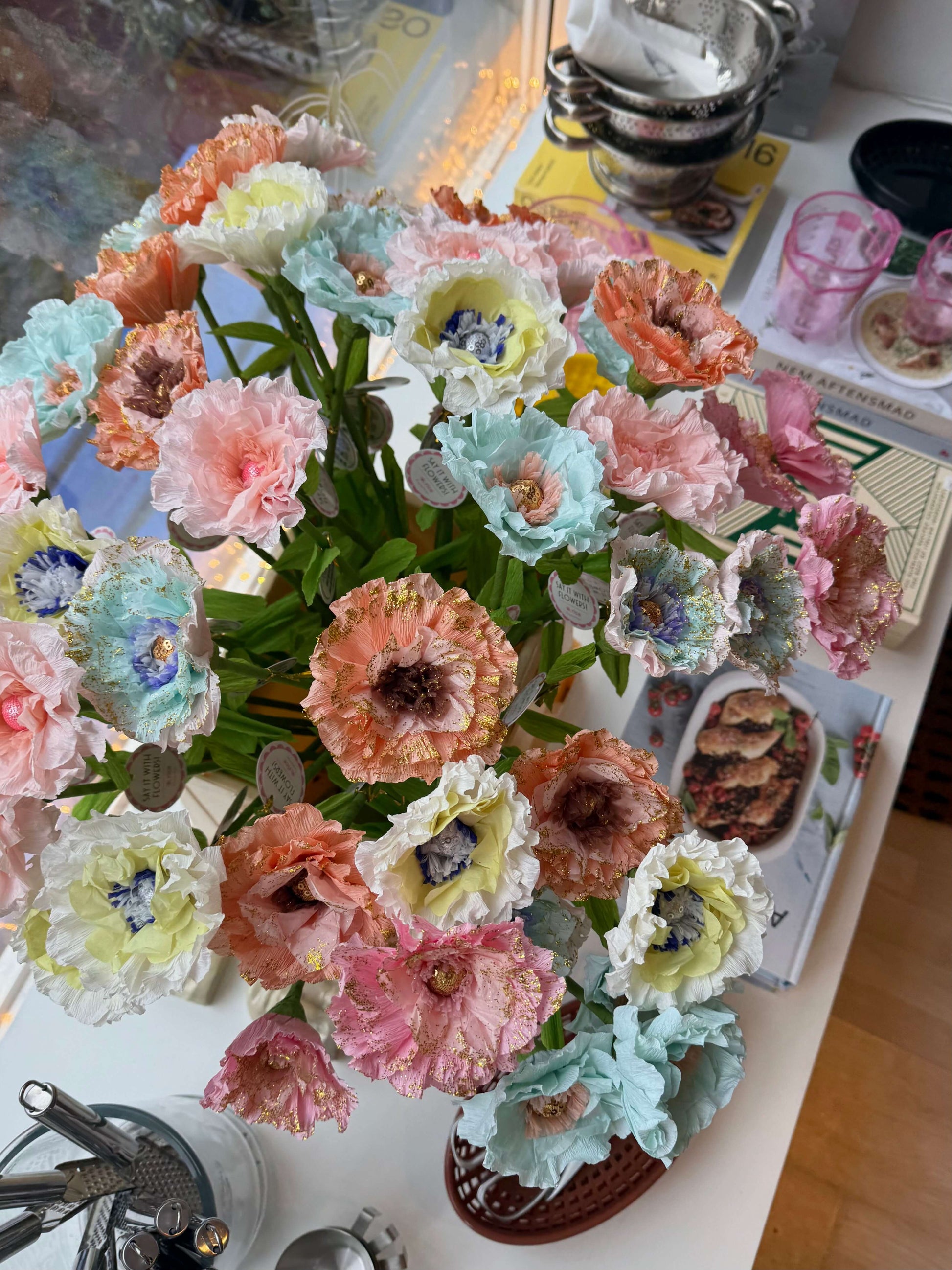 Buket med farverige papirblomster på spisebord