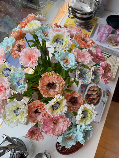 Buket med farverige papirblomster på spisebord