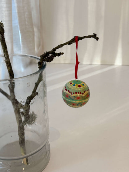 Håndmalede julekugler med rødt silkebånd