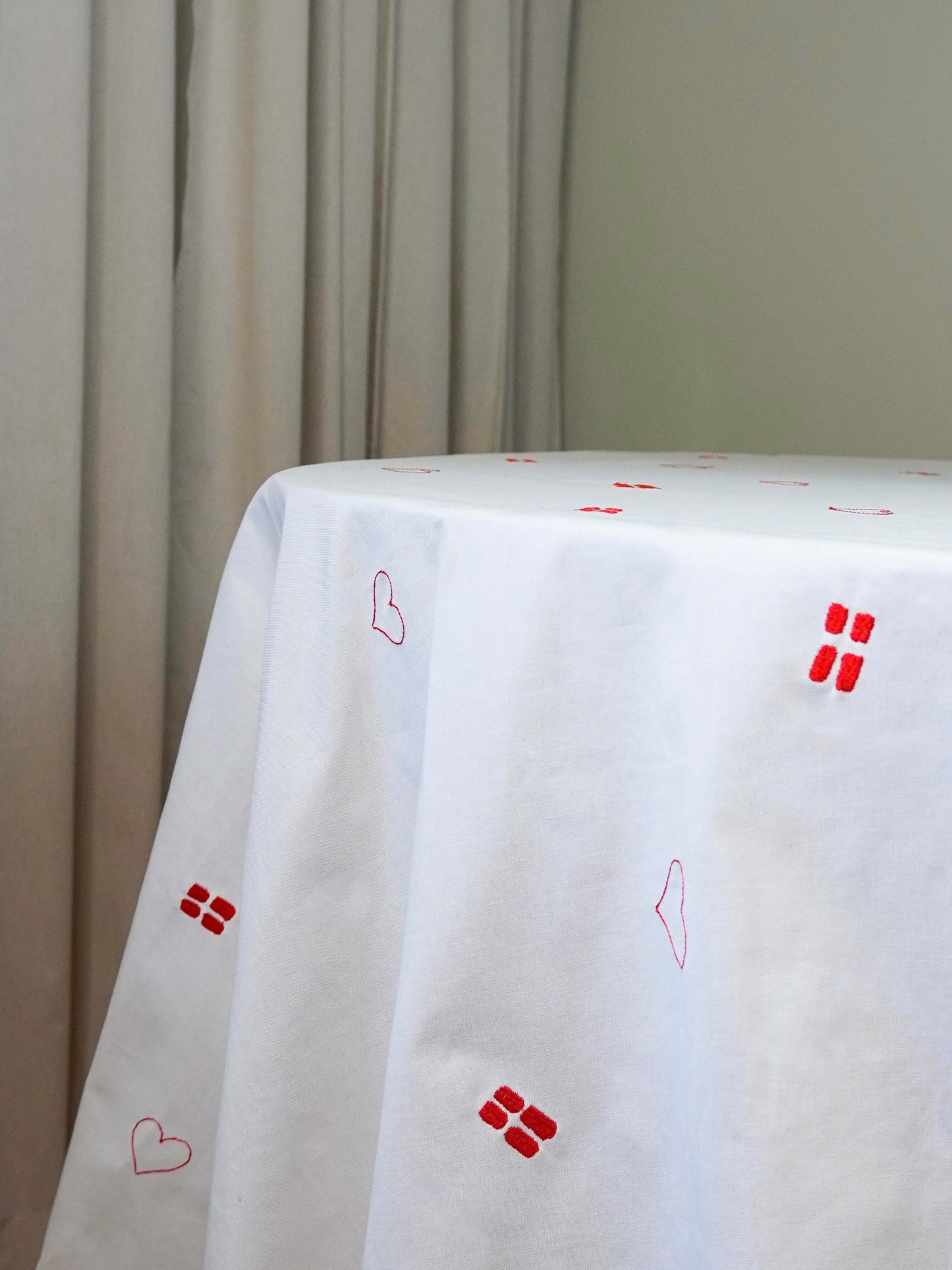 Detaljebillede af broderede flag og hjerter på Celebration Dug – en tidløs dug designet til fødselsdage og særlige fejringer.