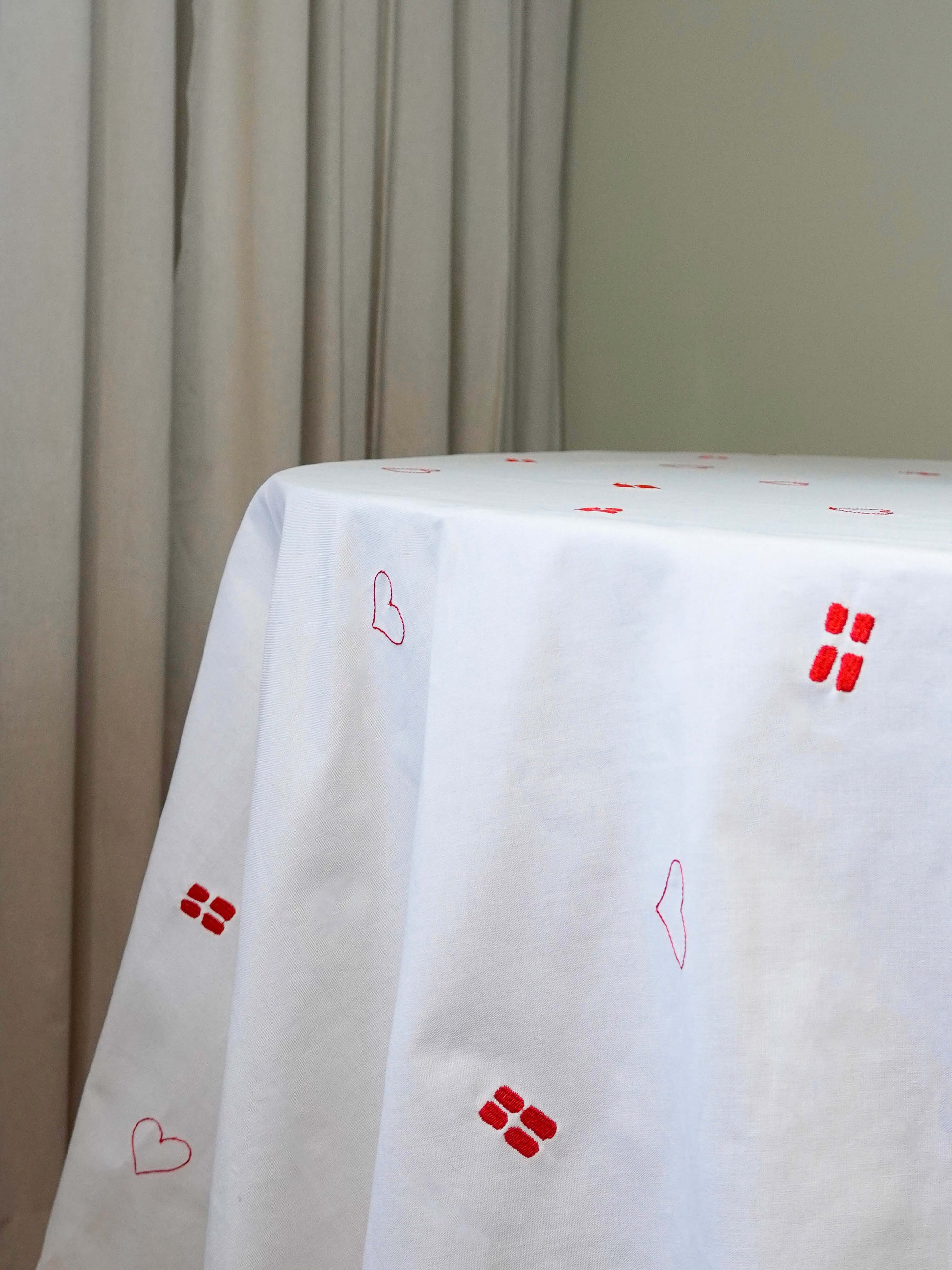 Detaljebillede af broderede flag og hjerter på Celebration Dug – en tidløs dug designet til fødselsdage og særlige fejringer.