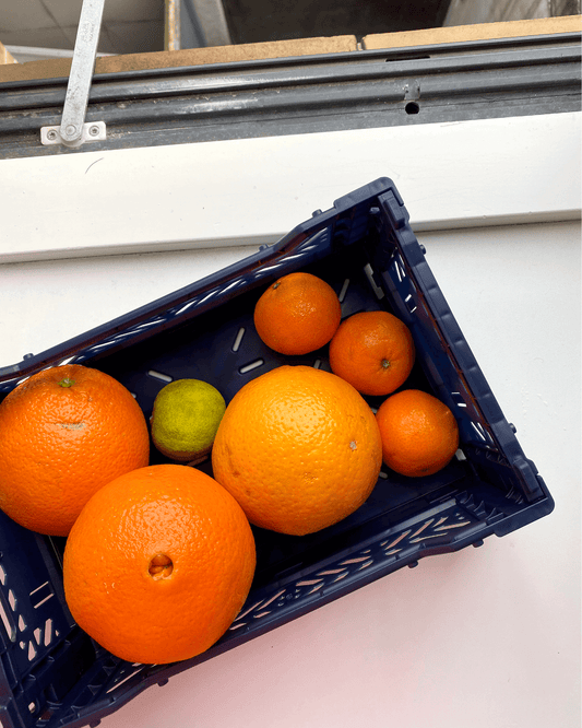 Aykasa Mini foldekasse i Navy, fyldt med appelsiner og lime – ideel til opbevaring i køkkenet.