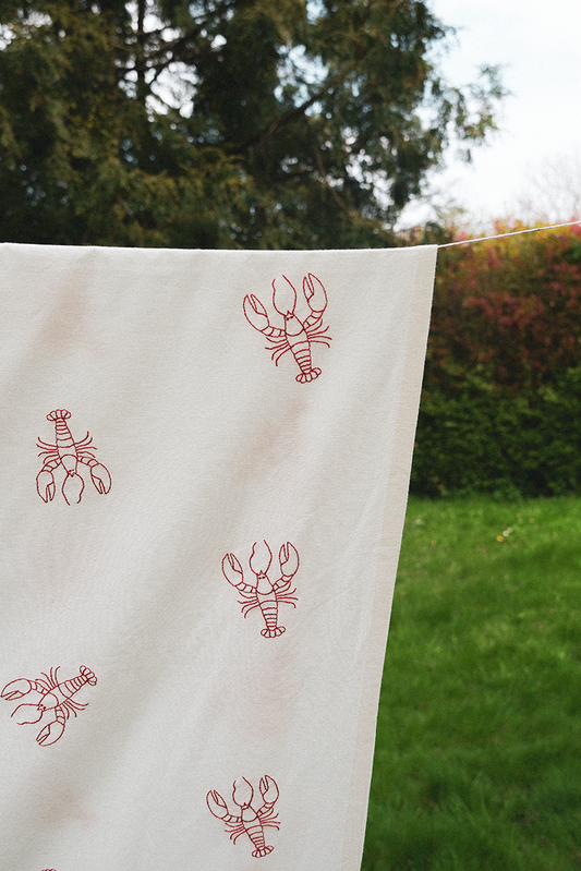 Hummer dug – broderet dug med håndtegnede hummere. Lavet i 100% økologisk bomuld og skaber en maritim stemning til middagsbordet."