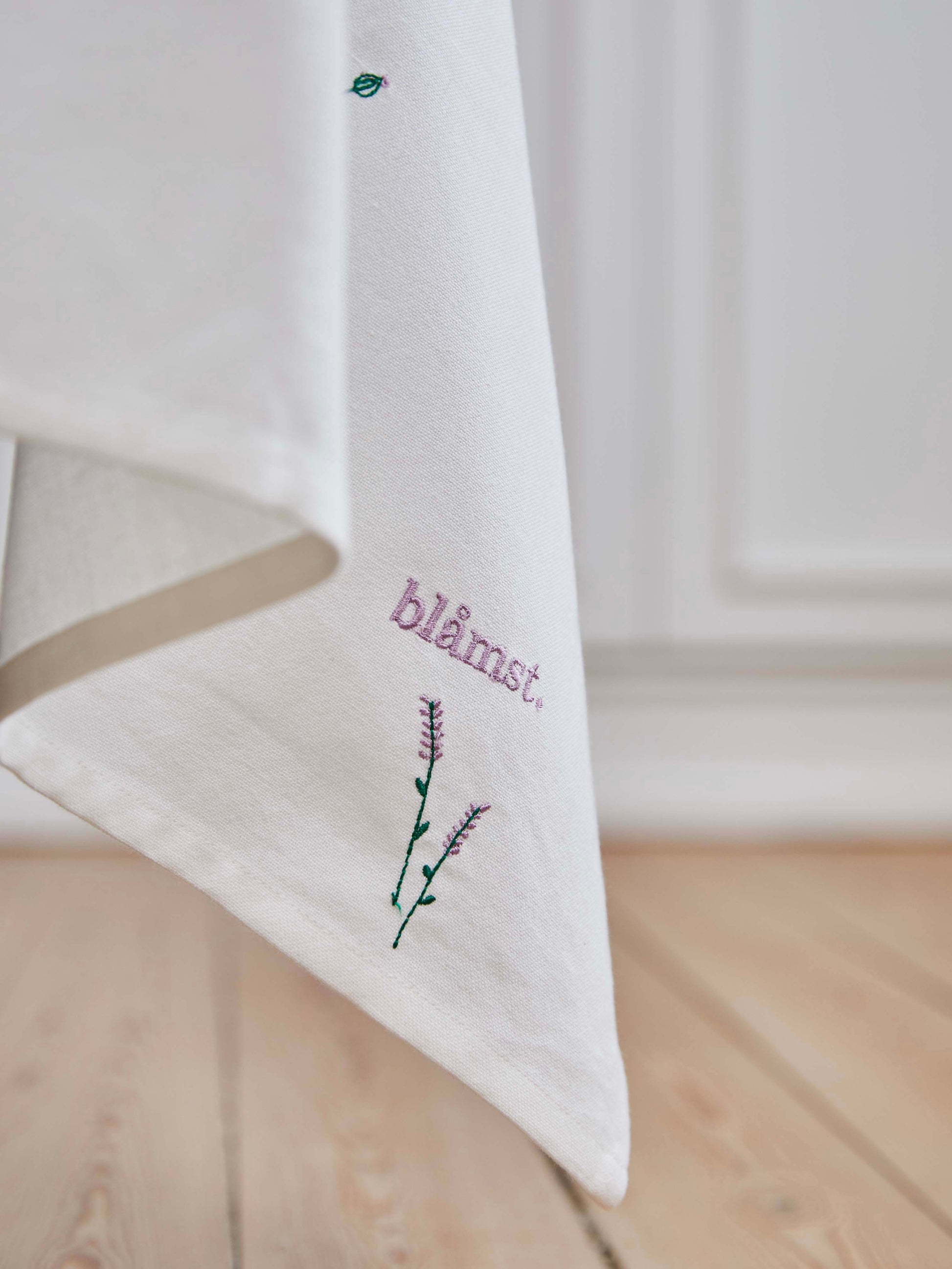 Blåmst Flower Dug i brug – en stemningsfuld borddækning med broderede blomster, der tilføjer varme og karakter til måltidet.