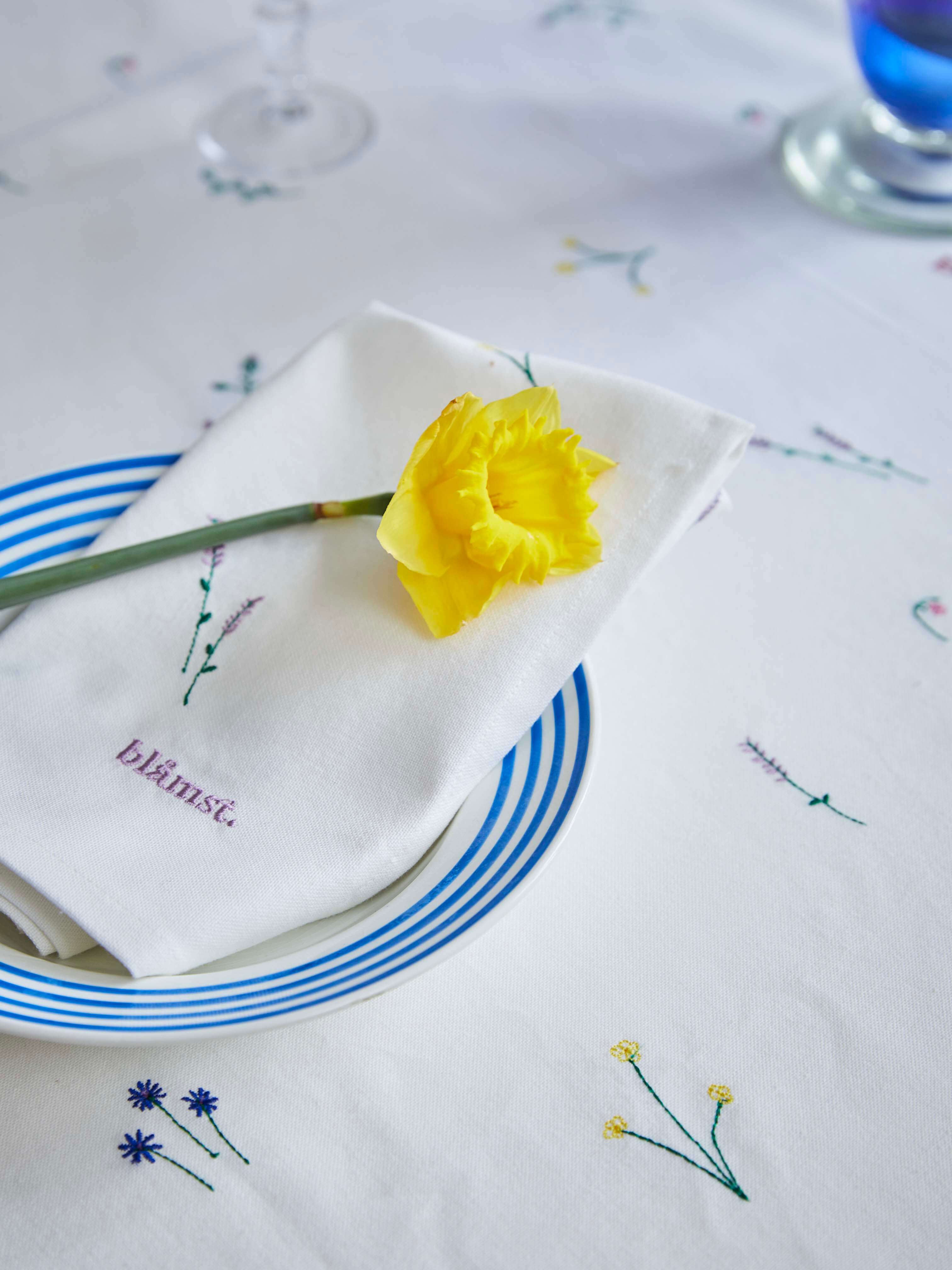 Nærbillede af Flower Dug fra Blåmst – fine broderede markblomster på en smuk, holdbar dug i GOTS-certificeret bomuld.