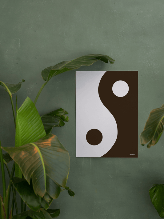 Brun Yin Yang plakat fra Blåmst, elegant kombineret med grønne planter i indretningen.