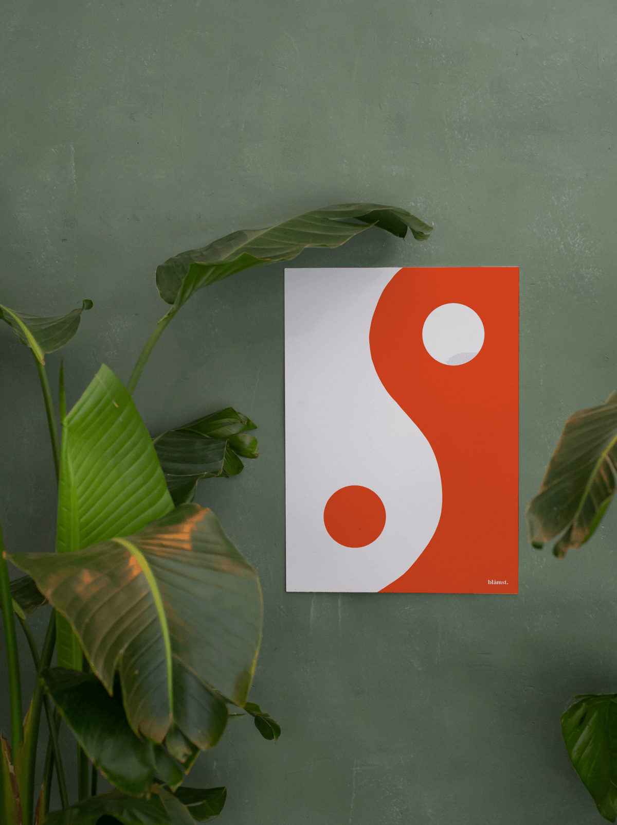 Orange Yin Yang plakat fra Blåmst på grøn væg, med et moderne og dristigt udtryk.